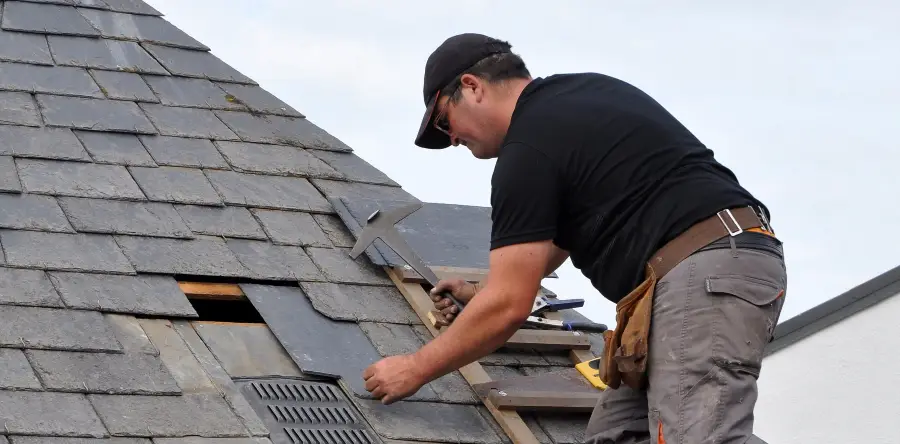 Roofing contractor fixing slate roof