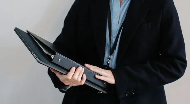 person holding folder of insurance certificates