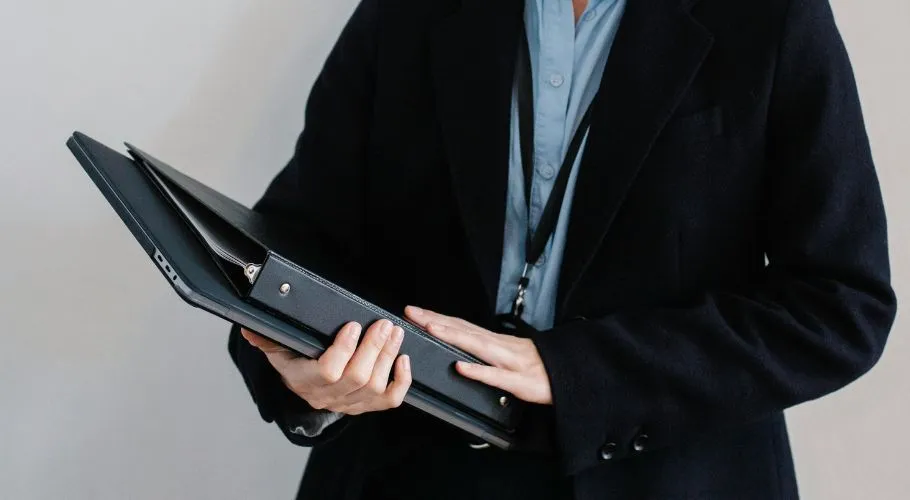 person holding folder of insurance certificates