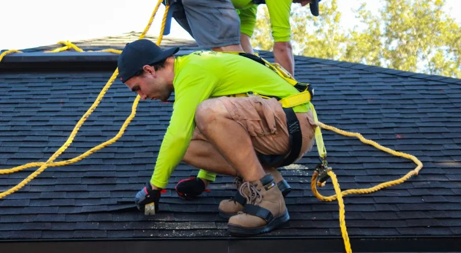 professional roofers wearing safety harnesses