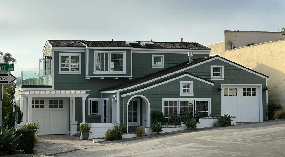 Two-story house with a white, black, and green color palette.