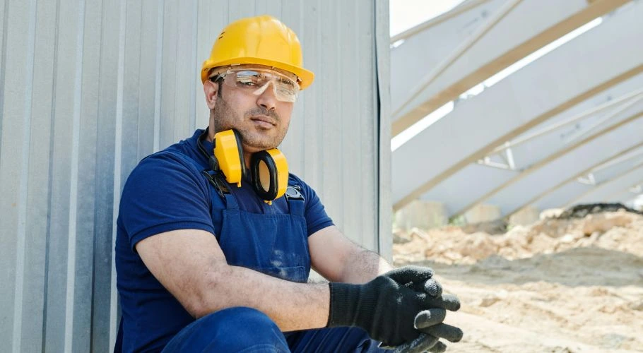 Man wearing safety goggles, a hard hat, and gloves.