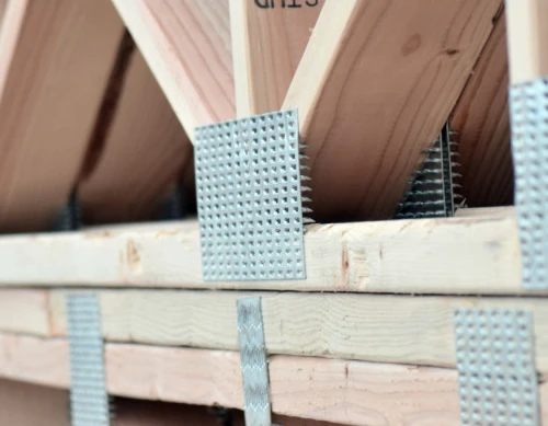 Hurricane straps displayed on a wooden frame house under construction