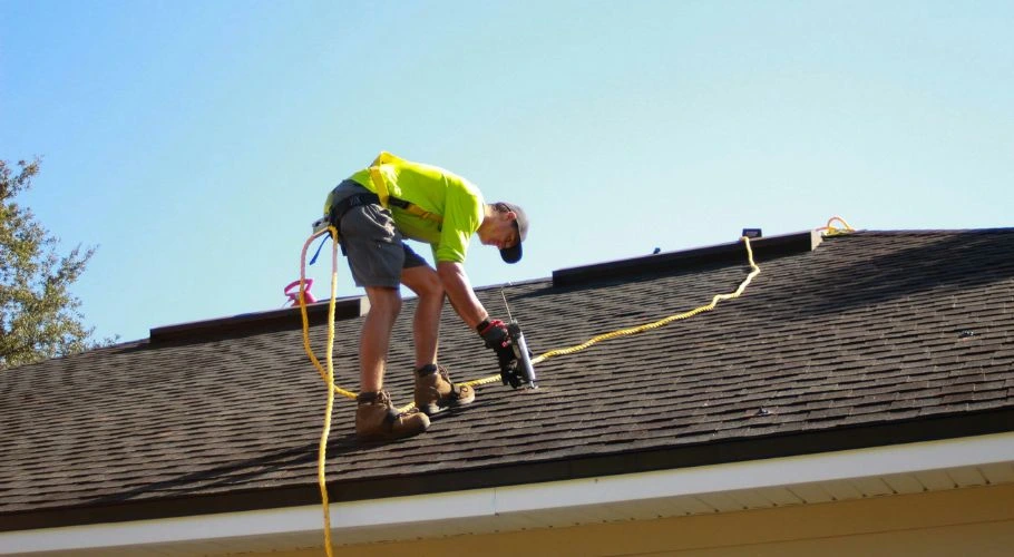 Roofer repairing a leak while following local building codes.