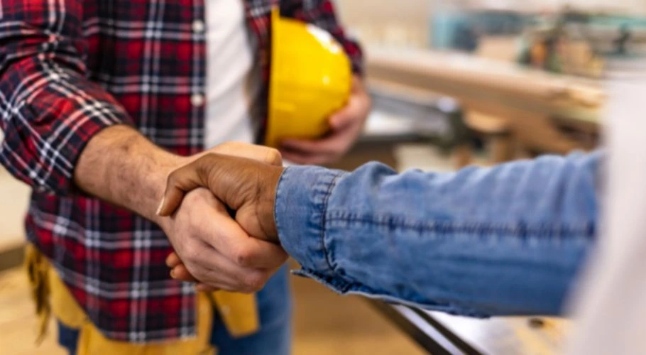 roofing contractor shaking hands with past client.webp