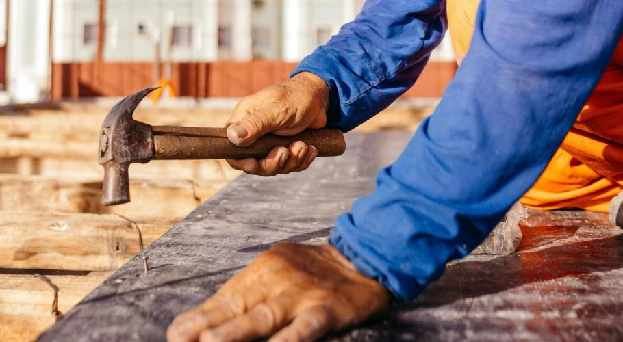 man nailing a roof decking